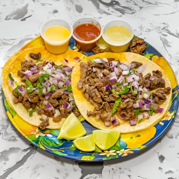 Two Tacos Don Chai carne asada tacos with onion, cilantro, lime, and three sauces.